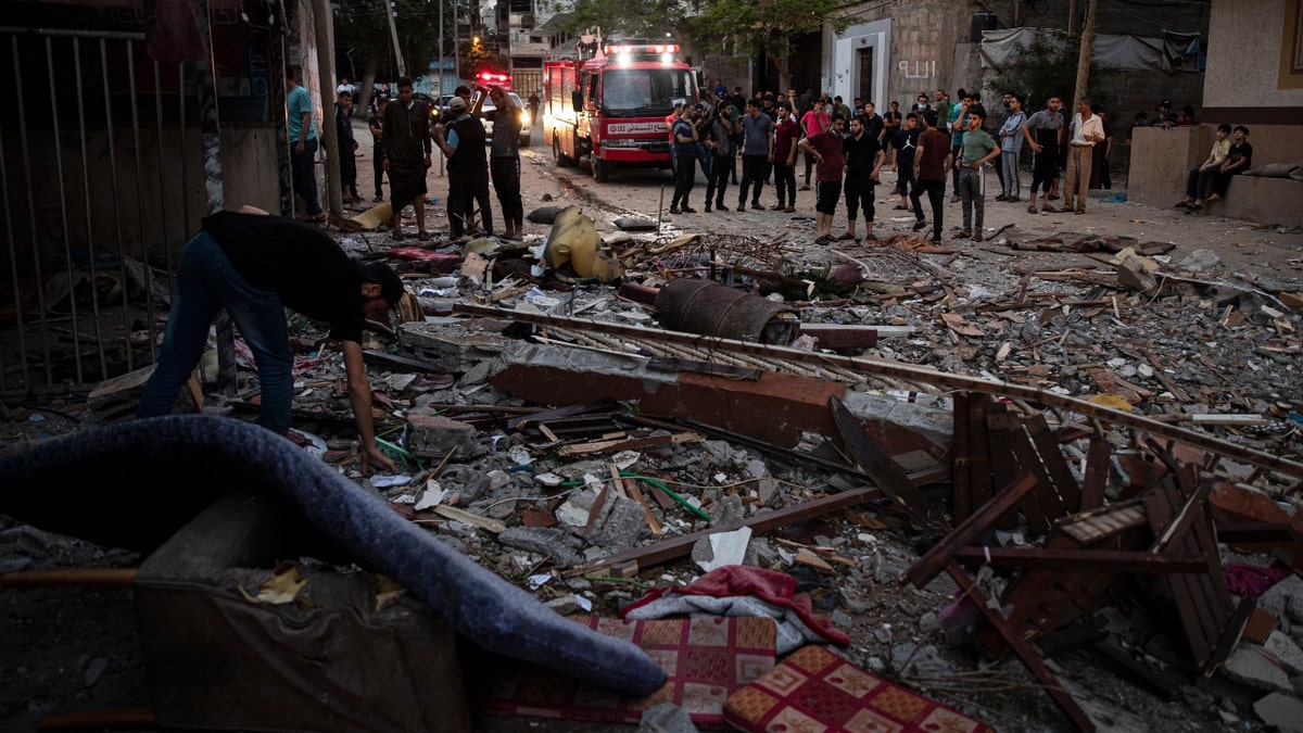 A Palestinian man inspects the rubble of a partially destroyed residential building after it was hit by Israeli missile strikes, at the Shate refugee camp, Gaza City, early Tuesday, May. 11, 2021. (AP Photo/Khalil Hamra)