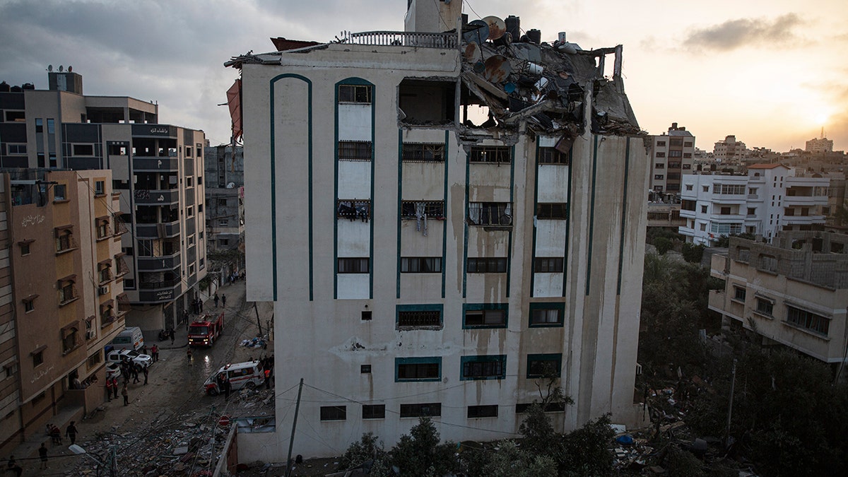 Palestinians search for survivors under the rubble of a destroyed rooftop of a residential building which was hit by Israeli missile strikes, at the Shati refugee camp in Gaza City, early Tuesday, May. 11, 2021. (AP Photo/Khalil Hamra)