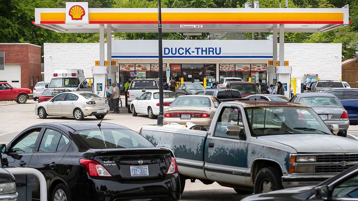 Customers fill up their vehicles with fuel at the Cupboard Food Store, foreground, and the Duck-Thru across in Scotland Neck, N.C., on Tuesday, May 11, 2021. 