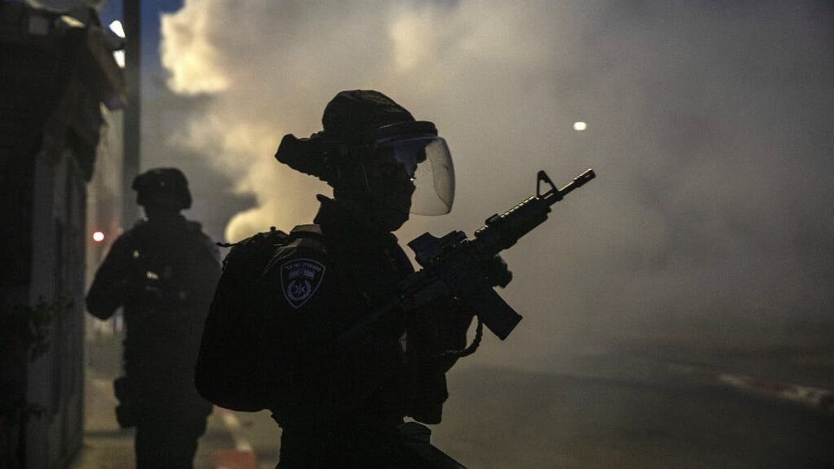 Israeli forces run during clashes with Israeli Arabs in the Israeli mixed city of Lod, Israel, Tuesday, May 11,2021. (AP Photo/Heidi Levine)