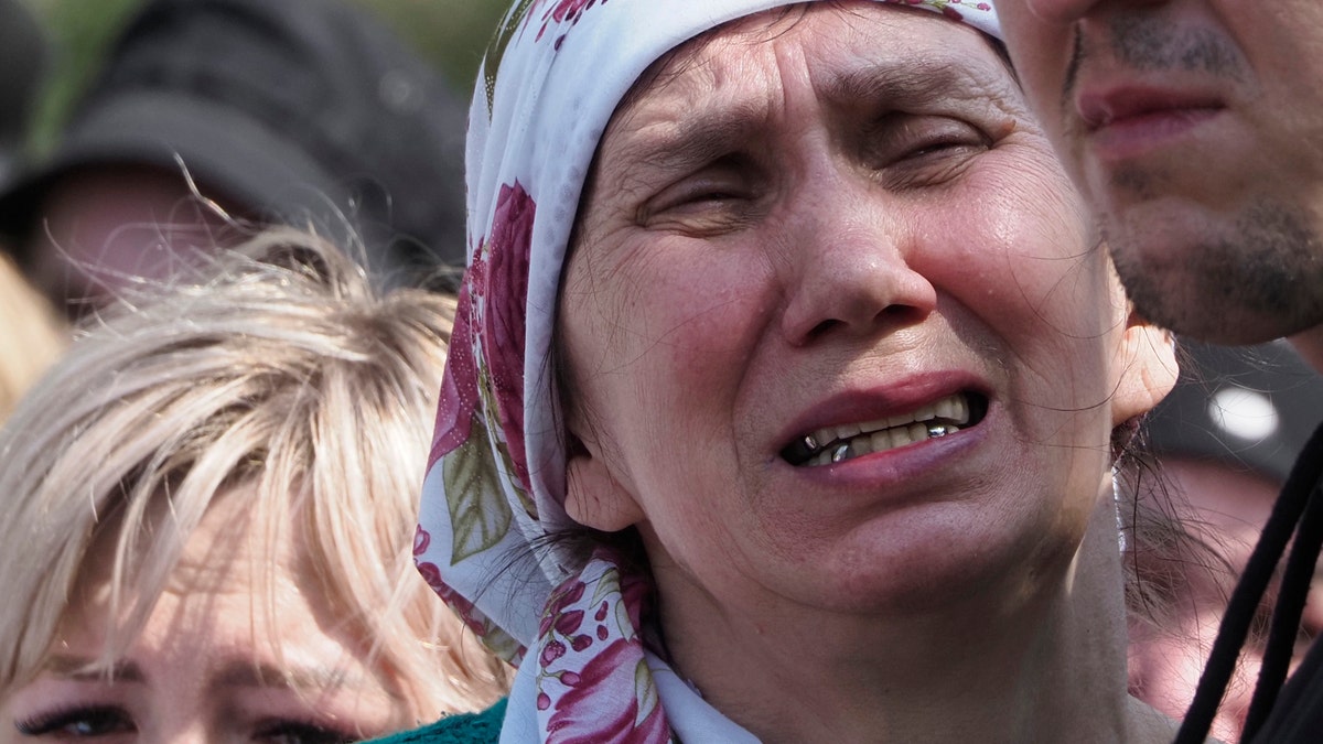 A woman cries during the funeral of Elvira Ignatieva, an English language teacher who was killed at a school shooting on Tuesday in Kazan, Russia, Wednesday, May 12, 2021. Russian officials say a gunman attacked a school in the city of Kazan and Russian officials say several people have been killed. Officials said the dead in Tuesday's shooting include students, a teacher and a school worker. Authorities also say over 20 others have been hospitalised with wounds. (AP Photo/Dmitri Lovetsky)
