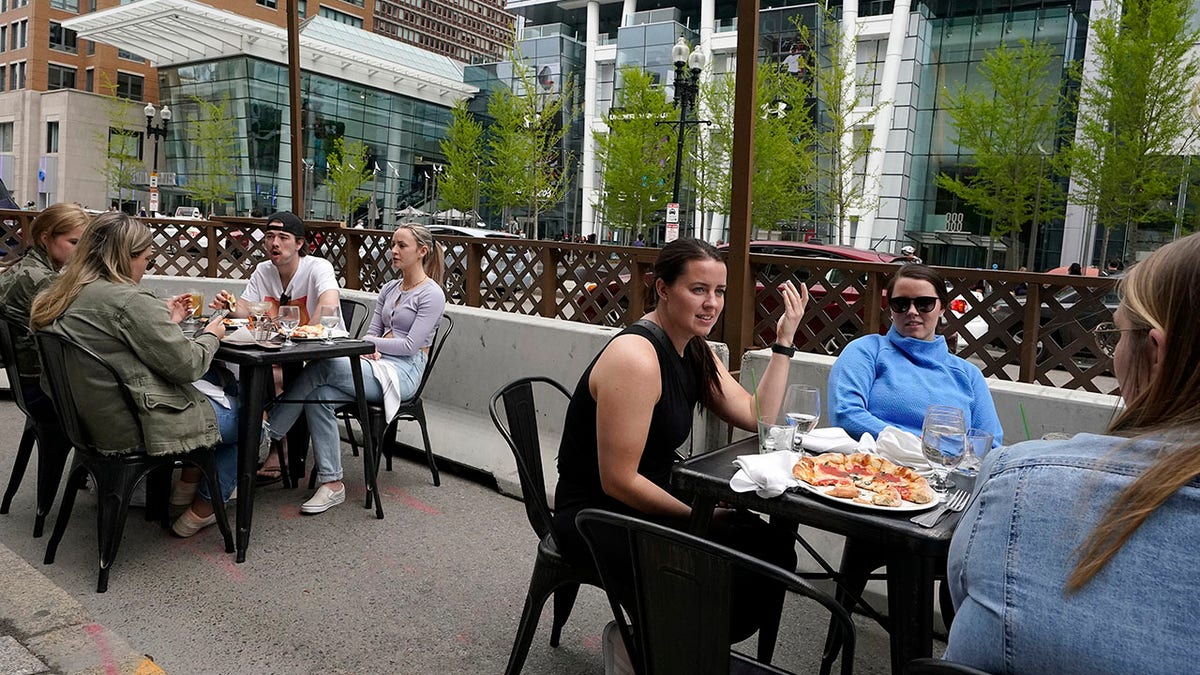 FILE - In this Sunday, May 2, 2021 file photo, patrons seated at outdoor tables at a restaurant converse and dine in Boston. (AP Photo/Steven Senne, File)