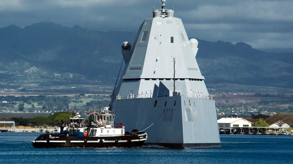 FILE - The guided missile destroyer USS Zumwalt is assisted by a tugboat at Joint Base Pearl Harbor-Hickam, in this Tuesday, April 2, 2019, file photo, in Honolulu. The electric-drive, angular Zumwalt was commissioned into service, but its 155mm advanced gun system is being scrapped because its munitions are too expensive. (Craig T. Kojima/Honolulu Star-Advertiser via AP, File)