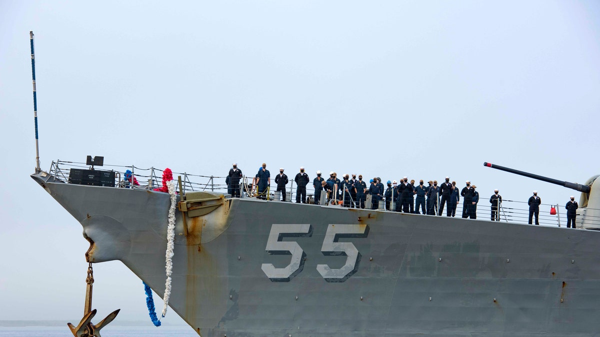 In this photo provided by the U.S. Navy, sailors aboard the guided missile destroyer USS Stout handle mooring lines during the ship's return to home port at Naval Station Norfolk, in Norfolk, Va., in this Oct. 12, 2020, photo. The USS Stout showed rust as it returned from the 210-day deployment. The rust was quickly removed, and the ship repainted. But the rusty ship and its weary crew underscored the costly toll of deferred maintenance on ships and long deployments on sailors. (Spc. Jason Pastrick/U.S. Navy via AP)