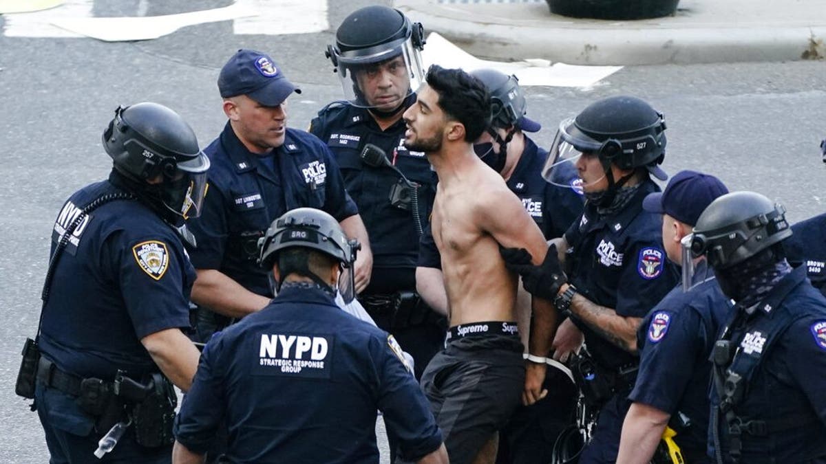 A man is detained by police as Palestinian supporters gather during a demonstration near the United Nations headquarters Tuesday, May 18, 2021, in New York. (AP Photo/Frank Franklin II)