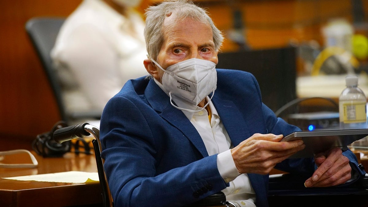 Robert Durst holds a device to read the real-time spoken script as he appears in the courtroom of Judge Mark E. Windham as attorneys begin opening statements in the trial of the real estate scion charged with murder of longtime friend Susan Berman, at Los Angeles County Superior Court, Tuesday, May 18, 2021, in Inglewood, Calif. 