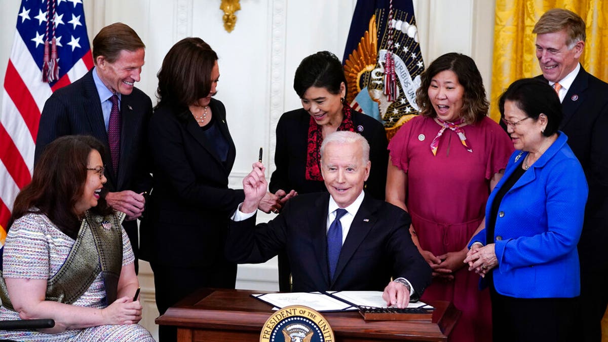President Joe Biden hands out a pen after signing the COVID-19 Hate Crimes Act, in the East Room of the White House, Thursday, May 20, 2021, in Washington. Clockwise from left, Sen. Tammy Duckworth, R-Ill., Sen. Richard Blumenthal, D-Conn., Vice President Kamala Harris, Rep. Judy Chu, D-Calif., Rep. Grace Meng, D-N.Y., Rep. Don Beyer, D-Va., and Sen. Mazie Hirono, D-Hawaii. (AP Photo/Evan Vucci)
