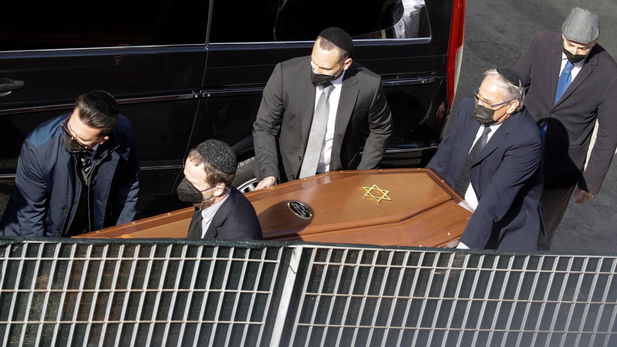 A coffin is carried by members of the Jewish community at the morgue of Verbania Hospital, in Verbania, Italy, Wednesday, May 26, 2021. A prayer ceremony for the Jewish victims took place in Verbania Wednesday morning, before the bodies of the dead were released to return to their homes for funerals and burials. Three people were arrested following a cable car disaster that killed 14 people, after the lead cable apparently snapped and the cabin careened back down the mountain until it pulled off the line and crashed to the ground. (AP Photo/Luca Bruno)