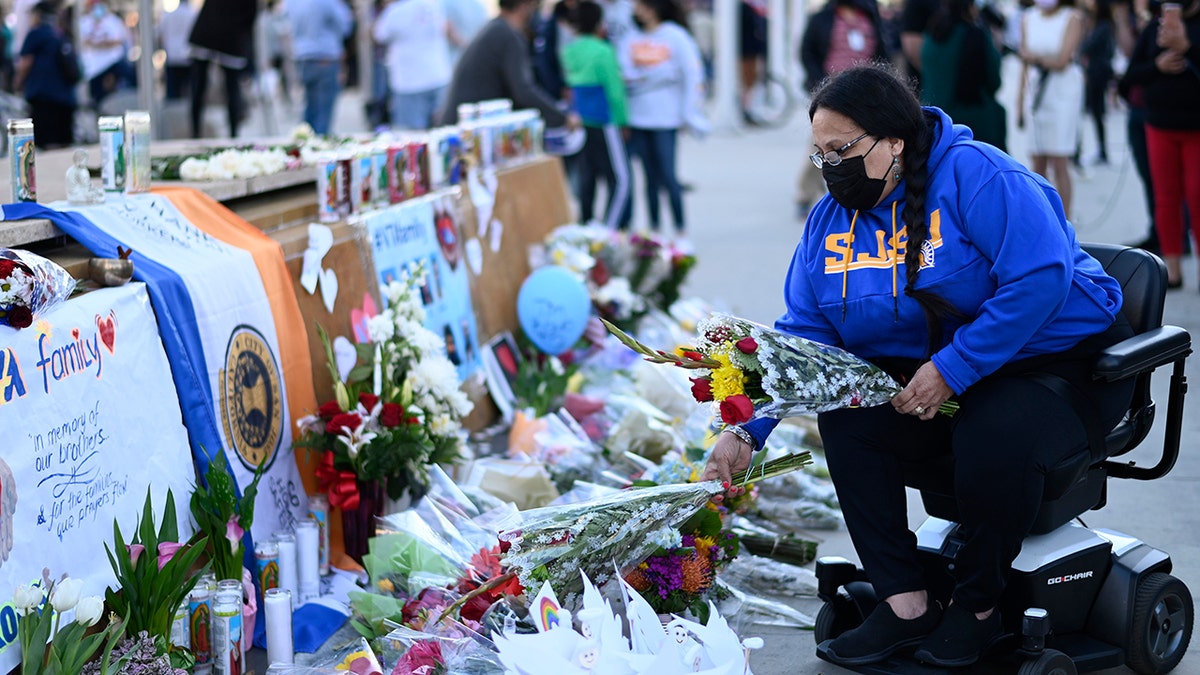 Diana Carreras places flowers at a vigil at City Hall in San Jose, California, Thursday, May 27, 2021, in honor of the multiple people killed when a gunman opened fire at a rail yard the day before. (Associated Press)