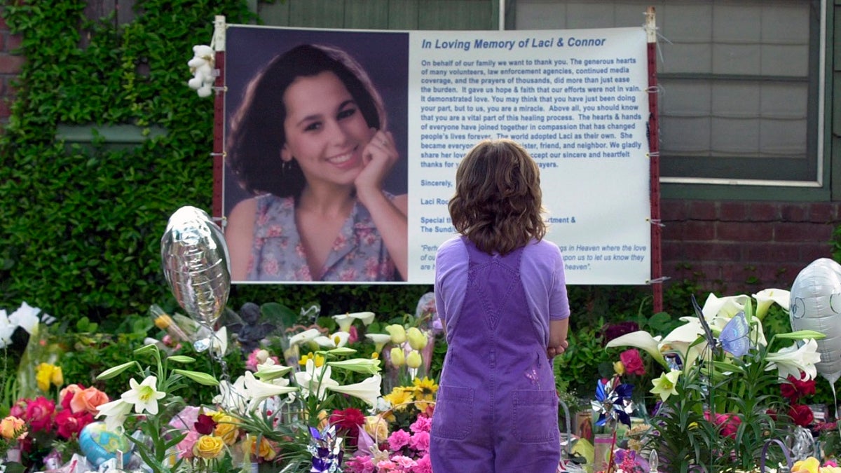 In this April 21, 2003 file photo, Sarah Kellison stands in front of a memorial in honor of Laci Peterson outside the house Laci shared with her husband Scott Peterson in Modesto, Calif. (AP Photo/Marcio Jose Sanchez, File)