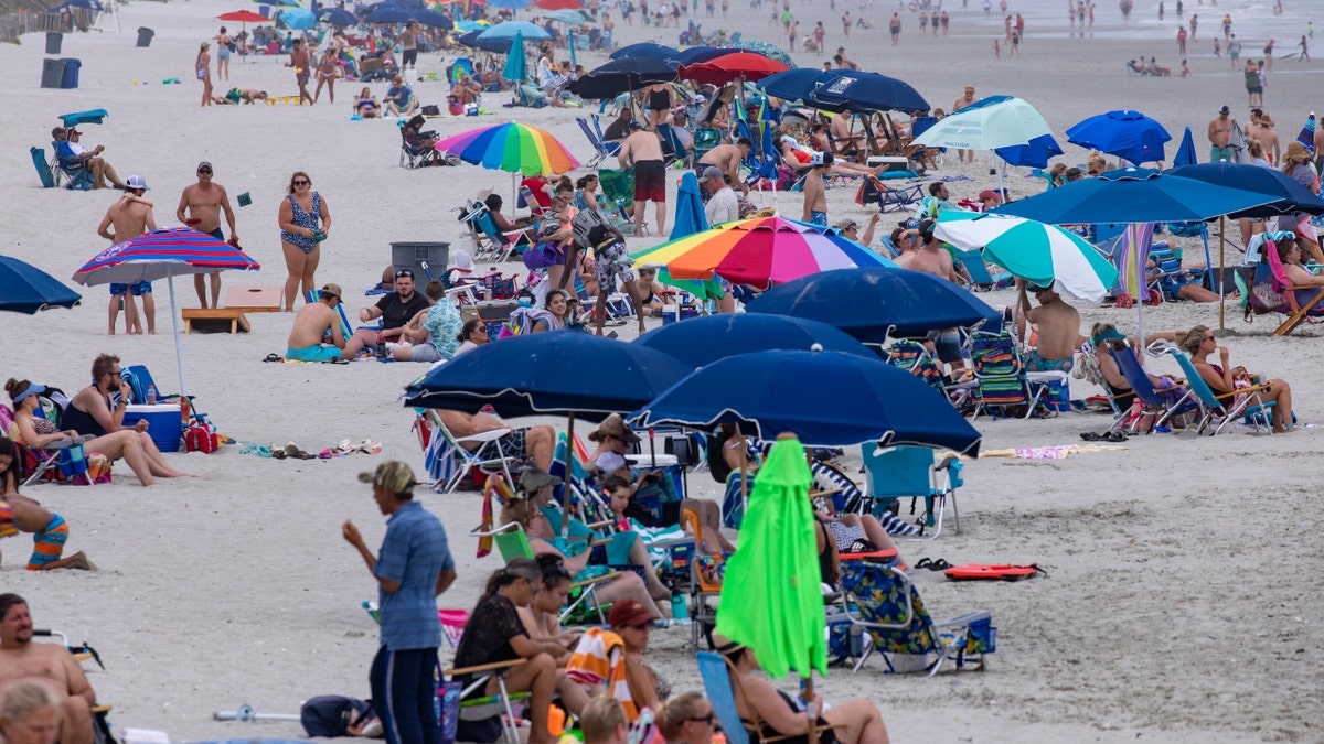 Beachgoers gather in the Cherry Grove section of North Myrtle Beach, S.C., Saturday, May 29, 2021. (Jason Lee/The Sun News via AP)