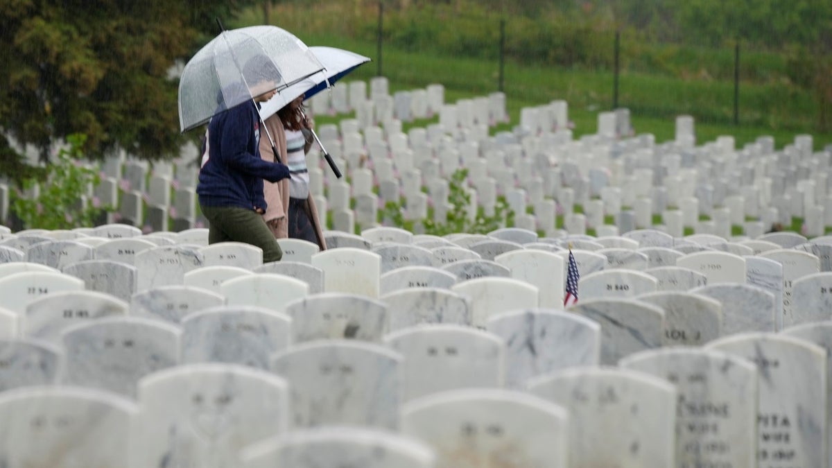 Woman carries umbrella while in cemetery on Memorial Day