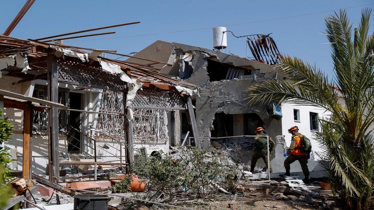 Israeli soldiers inspect a house damaged by a missile fired from the Gaza Strip in the southern Israeli city of Ashkelon on Tuesday. (AP)