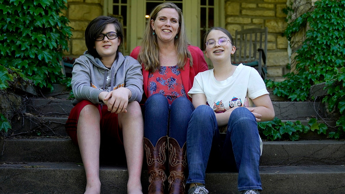 May 4, 2021: Heather Ousley, who plans to get her kids vaccinated as soon as they are eligible, sits with her older children Elliannah, 15, right, and Samuel, 13, in front of their home in Merriam, Kan.