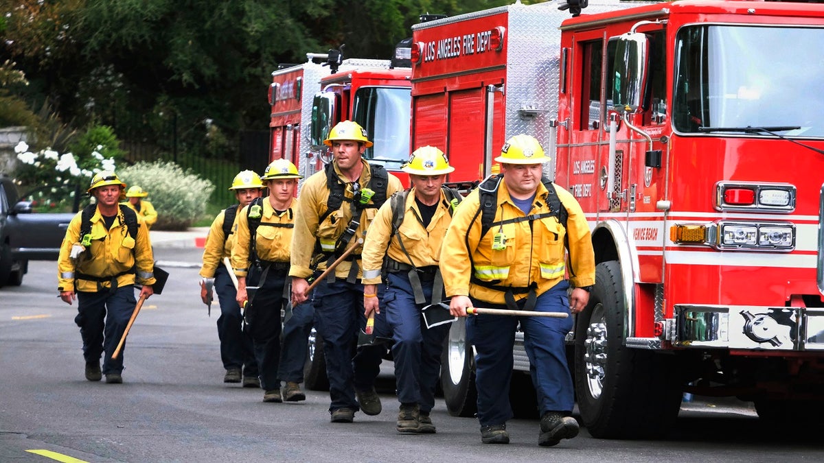 Firefighters walk in line to fight the wildfire in the Pacific Palisades area of Los Angeles on Sunday. (AP)