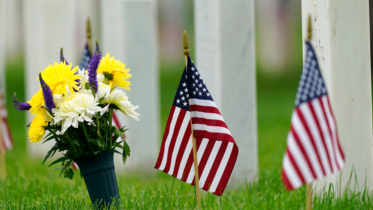 Flags and tributes mark the Memorial Day holiday are placed among the headstones in Fort Logan National Cemetery Monday, May 31, 2021, in southeast Denver. More than 105,000 graves were decorated with flags to mark the holiday.