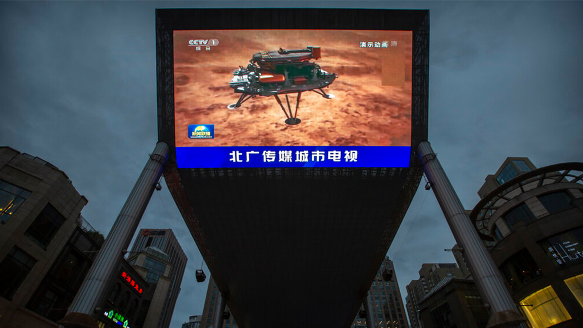 A Chinese state media broadcast of a news report about the country's successful landing of a probe on Mars is shown on a large video screen at a shopping mall in Beijing, Saturday, May 15, 2021.  