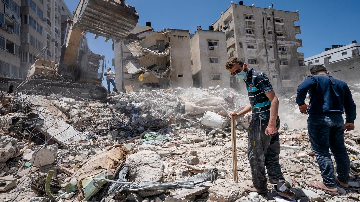 Heavy construction equipment is used to sift through rubble Thursday to uncover valuables before it is transported away from the scene of a building in Gaza City that was destroyed in a recent airstrike. (AP)
