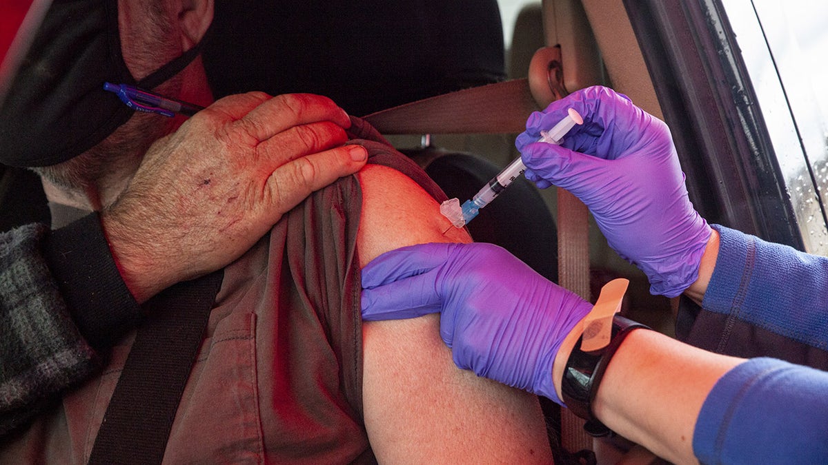 A healthcare worker administers a dose of the Moderna Covid-19 vaccine to a person in a vehicle at a drive-thru vaccination site at the Meigs County fairgrounds in Pomeroy, Ohio, U.S., on Thursday, March 18, 2021. 