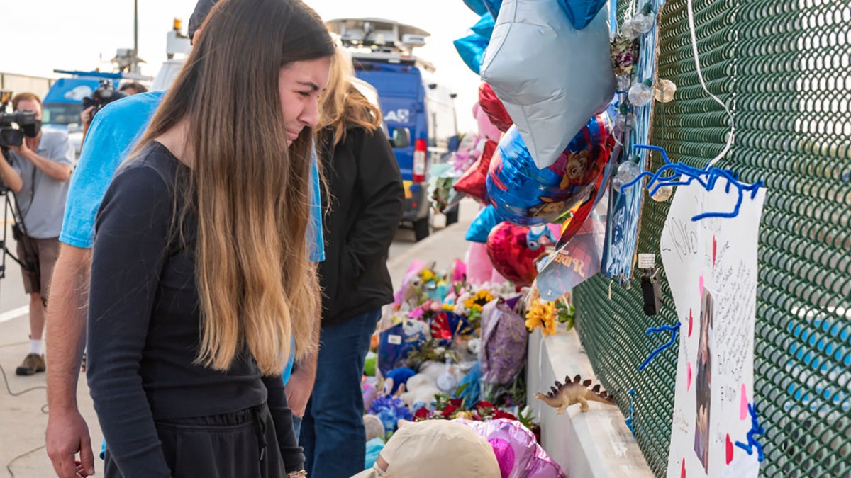 Alexis Cloonan, sister of 6-year-old Aiden Leos, cries at the memorial erected on  freeway overpass in Orange, California, on Tuesday, May 25, 2021. (Getty Images)