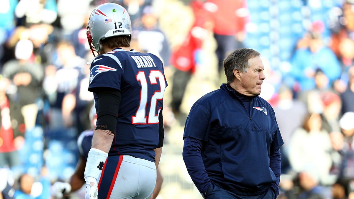 Tom Brady #12 of the New England Patriots and head coach Bill Belichick look on during warm ups before the AFC Championship Game against the Jacksonville Jaguars at Gillette Stadium on Jan. 21, 2018 in Foxborough, Massachusetts.  