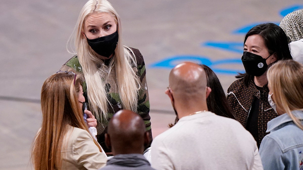 Former Olympic alpine skier and gold medal winner Lindsey Vonn, second from left, wears a mask as she talks to fans after attending Game 2 of an NBA basketball first-round playoff series between the Brooklyn Nets and the Boston Celtics, Tuesday, May 25, 2021, in New York. (AP Photo/Kathy Willens)
