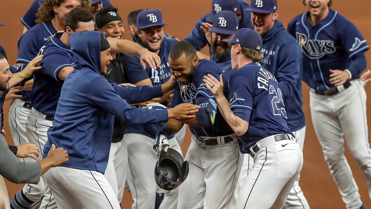 Tampa Bay Rays' Manuel Margot, center, is congratulated by teammates after his game-winning single against the Kansas City Royals during the 10th inning of a baseball game Wednesday, May 26, 2021, in St. Petersburg, Fla. The Rays won 2-1.