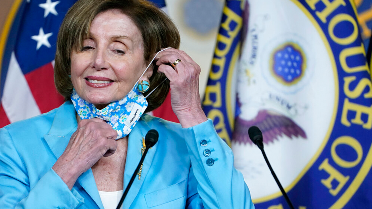 House Speaker Nancy Pelosi of Calif., takes off her face mask to talk to reporters on Capitol Hill in Washington, Wednesday, May 19, 2021, about legislation to create an independent, bipartisan commission to investigate the Jan. 6 attack on the United States Capitol Complex. 