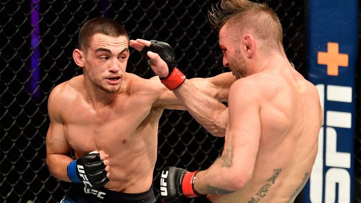 Ryan Benoit, left, punches Tim Elliott, right, in their flyweight fight during the UFC Fight Night event inside Flash Forum on UFC Fight Island on July 16, 2020 in Yas Island, Abu Dhabi, United Arab Emirates. (Photo by Jeff Bottari/Zuffa LLC via Getty Images)