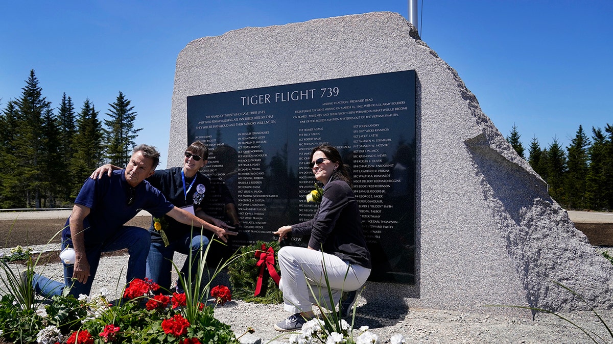 John Williams, of Peru, Indiana, left, and his sisters, Maria McCauley, of Branson, Missouri, center, and Susie Linale, of Omaha, Nebraska, pose at a monument to honor the military passengers of Flying Tiger Line Flight 739, Saturday, May 15, 2021, in Columbia Falls, Maine. Their father, SFC Albert Williams, Jr., was among those killed on the secret mission to Vietnam in 1962. (Associated Press)