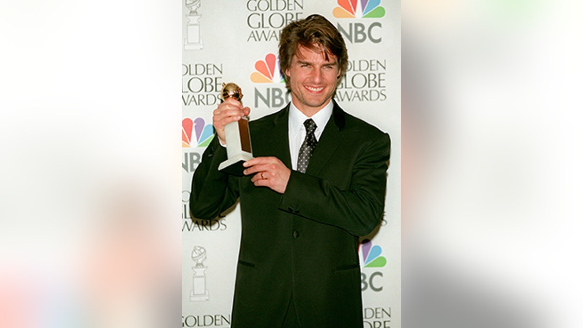 Tom Cruise holding a Golden Globe award