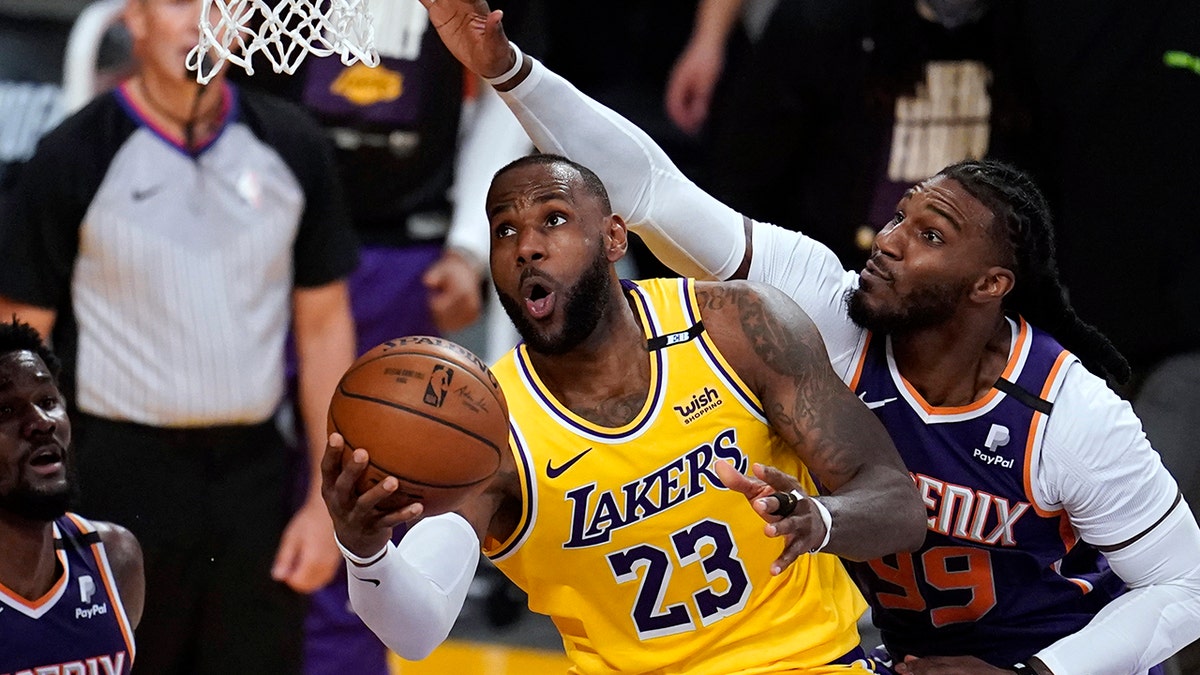 Los Angeles Lakers forward LeBron James, center, scores past Phoenix Suns forward Jae Crowder, right, during the second half in Game 3 of an NBA basketball first-round playoff series Thursday, May 27, 2021, in Los Angeles. (AP Photo/Marcio Jose Sanchez)