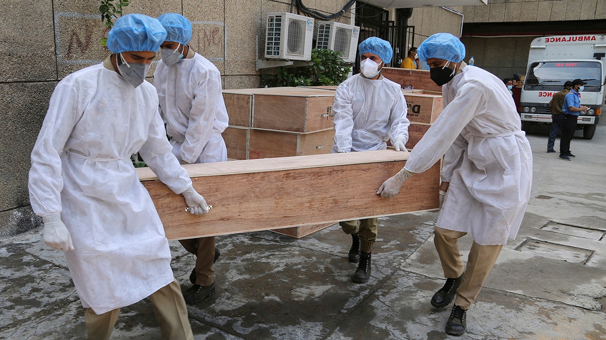 May 19, 2021: Jammu and Kashmir State Disaster Response Force soldiers carry empty coffins for transporting bodies of people who died of COVID-19 outside government medical hospital in Jammu, India.
