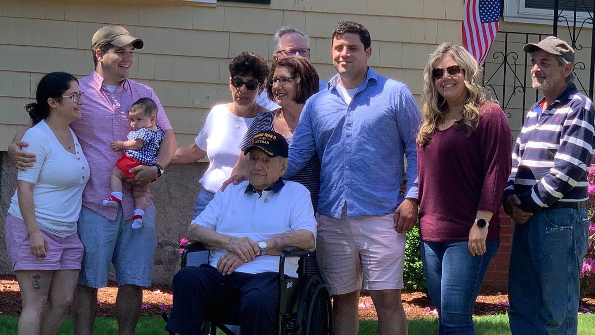 World War II veteran Anthony Grasso with his family in Norwood, Mass. just before he departs to give a final salute to the man who saved his life, Frank DuBose.