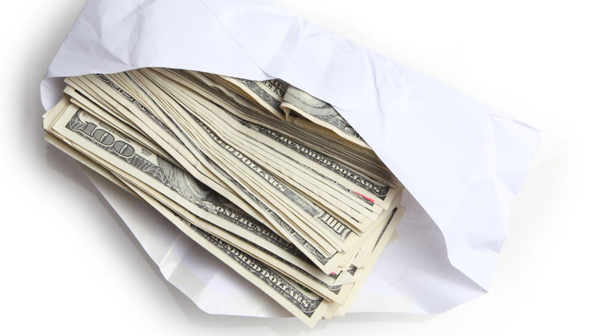 Envelope filled with stack of hundred dollar bills