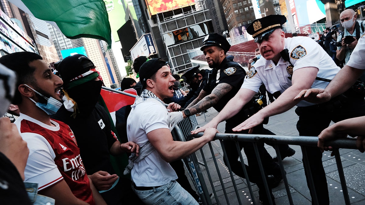 Pro-Palestinian protesters face off with a group of Israel supporters and police in a violent clash in Times Square on Thursday. 
