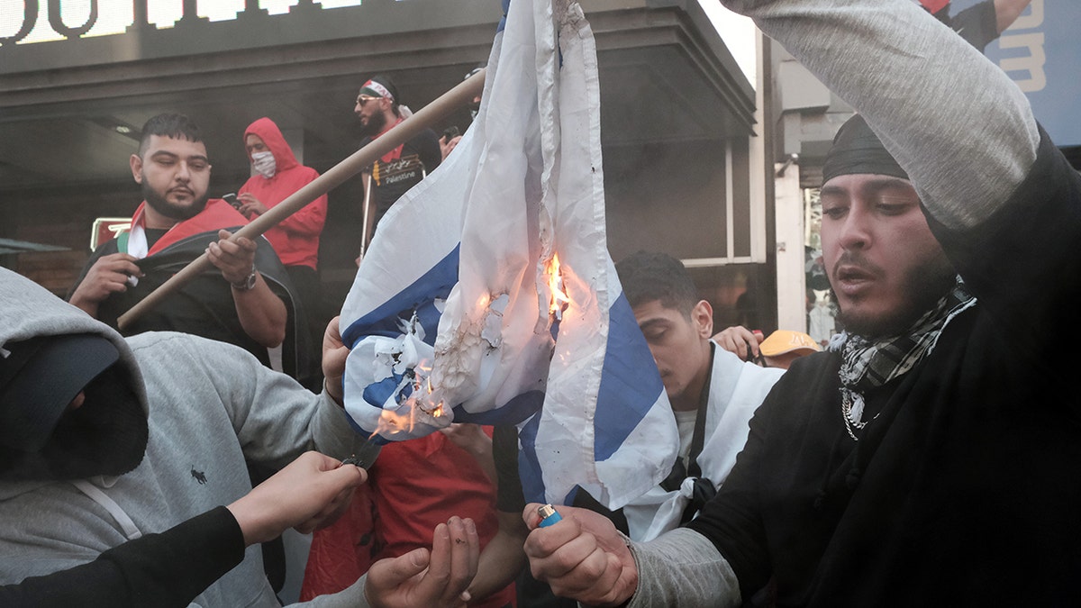Pro-Palestinian protesters burn the Israeli flag in New York City on Thursday. (Getty Images)