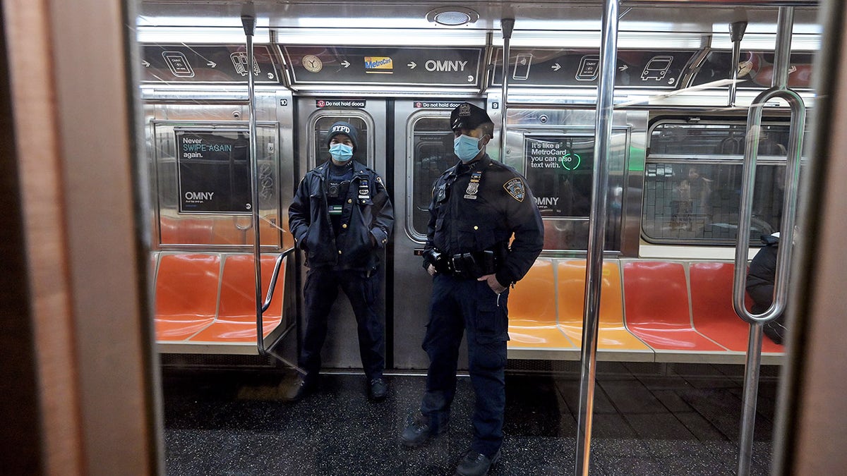 Two NYPD officers ride a downtown local 6 train leaving Union Square subway station in Manhattan, as the NYPD adds 644 police officers to patrol the subways after a homeless man stabbed and killed two people on the A train over the weekend, New York, NY, February 16, 2021. (Photo by Anthony Behar/Sipa USA)No Use Germany.