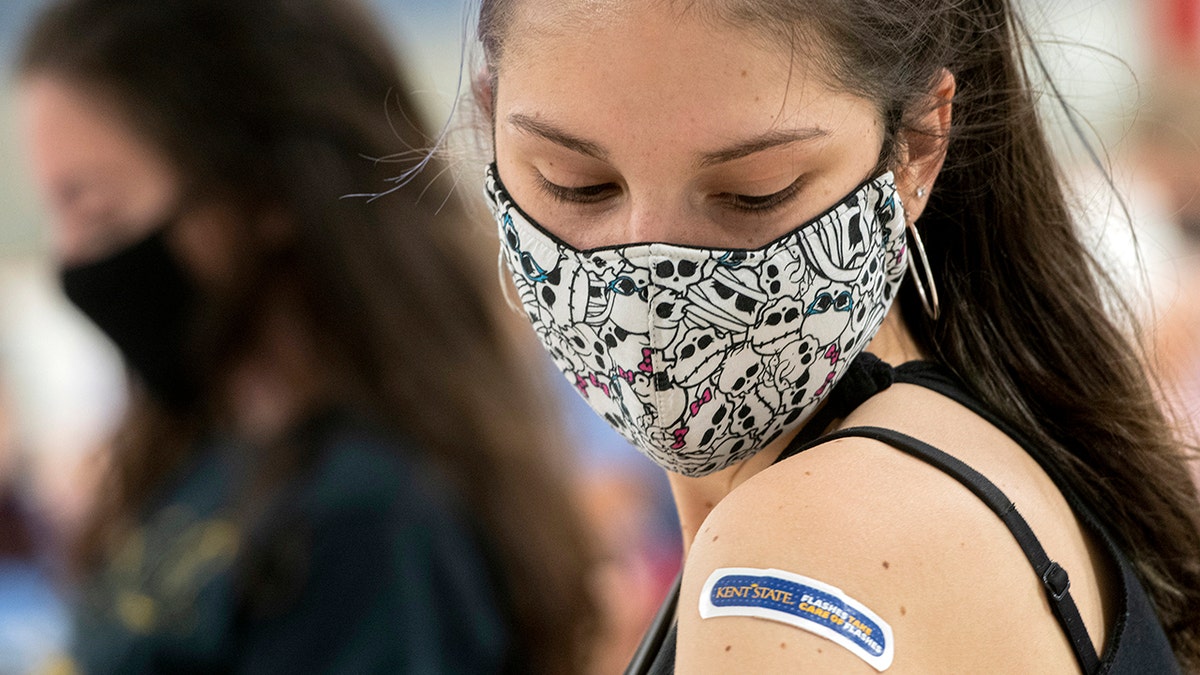 FILE: Kent State University student Regan Raeth, of Hudson, Ohio, looks at her vaccination bandage as she waits for 15 minutes after her shot in Kent, Ohio.