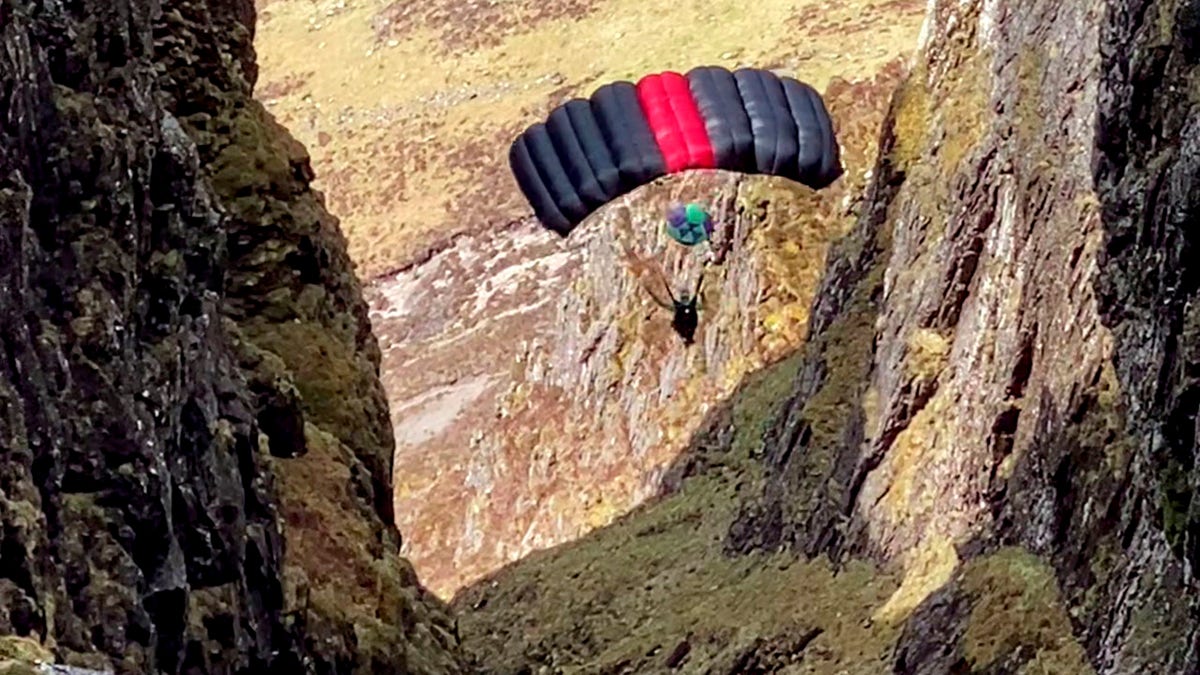 Nick Cowie filmed a base jumper leap off Aonach Eagach in Glen Coe, Scotland, and parachute through the narrow ridge.