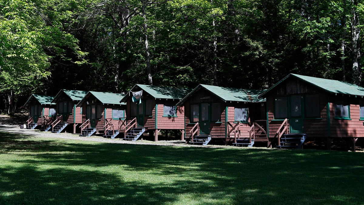 FILE - This Thursday, June 4, 2020 file photo shows a row of cabins at a summer camp in Fayette, Maine. On Friday, May 28, 2021, the Centers for Disease Control and Prevention posted guidance saying kids at summer camps can skip wearing masks outdoors, with some exceptions. Children who aren’t fully vaccinated should still wear masks outside when they’re in crowds or in sustained close contact with others – and when they are inside, and fully vaccinated kids need not wear masks indoors or outside, the CDC says. (AP Photo/Robert F. Bukaty, File)