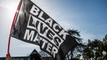 LOS ANGELES, CALIFORNIA, UNITED STATES - 2021/04/20: A protester waves a Black Lives Matter flag during the demonstration. Hours after the verdict of the Derek Chauvin trial, protesters meet outside of Los Angeles Mayor Eric Garcetti's home to protest his proposed funding of the Los Angeles Police Department. (Photo by Stanton Sharpe/SOPA Images/LightRocket via Getty Images)