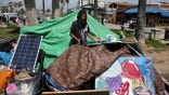 Vincent Digaetano, 52, paints pictures outside his tent, as the coronavirus disease (COVID-19) disease pandemic continues, on Venice Beach in Los Angeles, California, U.S., April 14, 2021. Picture taken April 14, 2021. REUTERS/Lucy Nicholson
