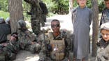 Jesse Melton III on active duty in Afghanistan in 2008, sitting alongside fellow Marines and Afghan children.