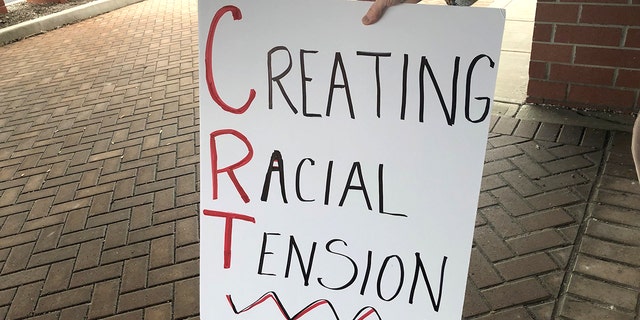 A protester holds a sign outside a building as the Noblesville school board meets inside on Tuesday, May 4, 2021. The protesters, who wouldn't provide their names, said they didn't want the schools to teach critical race theory, a concept that examines systemic racism as a part of American life. The district said it doesn't teach critical race theory.Noblesville Sign