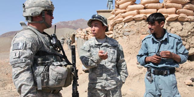 U.S. Army 1st Lt. Paul Worthington (left) listens to an interpreter while speaking with an Afghan National Policeman about security issues during a visit to a National Police outpost in the Jabal Saraj district of the Parwan province of Afghanistan on Oct. 8, 2010.