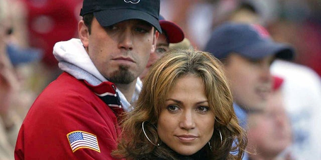 Actress-singer Jennifer Lopez and boyfriend, actor Ben Affleck, watch the New York Yankees take on the Boston Red Sox during Game 3 of the 2003 American League Championship Series on October 11, 2003, at Fenway Park in Boston, Massachusettes.  
