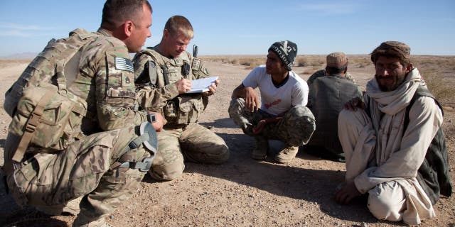 U.S. Army Staff Sgt. Nathaniel Johnson, U.S. Army Capt. James Nelson and Hader, interpreter, speak with elders in the Shorbak Desert, Kandahar Province, Afghanistan 9 Dec. 2011. (U.S. Army Photo by Spc. Phil Kernisan/Released)