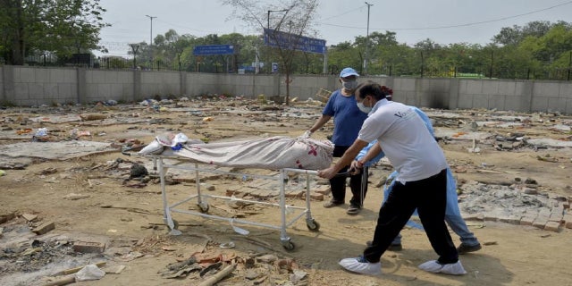 May 1, 2021: Body of a COVID-19 victim is wheeled in a ground that has been converted into a crematorium in New Delhi, India.