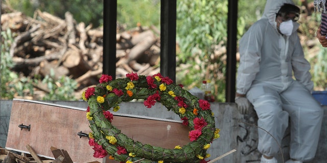 A wreath lies on the coffin of a COVID-19 victim before his cremation in Jammu, India, Friday, April 30, 2021. (Associated Press)